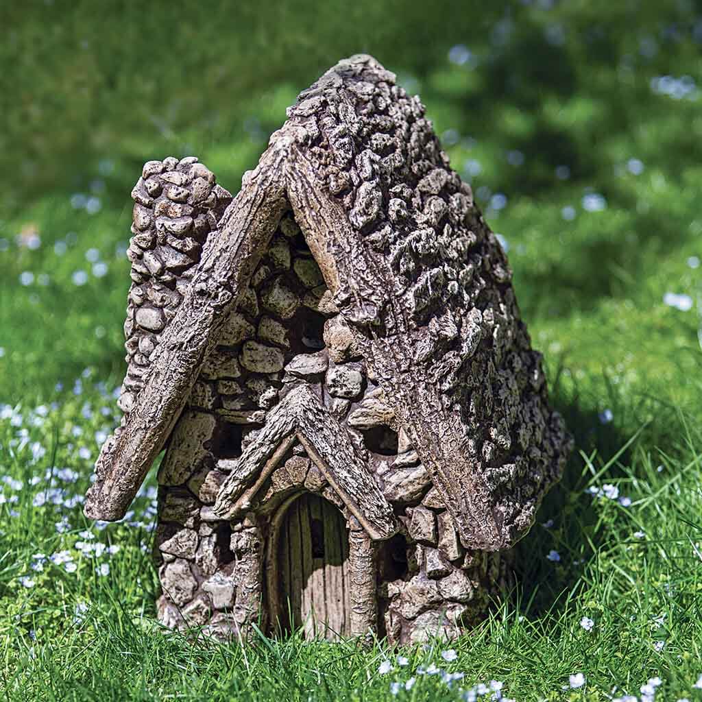 Decorative fairy house on grass with a blurred natural background