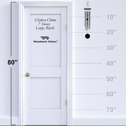 Woodstock Chimes wind chime next to a white door with height measurement scale.