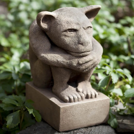 Stone gargoyle statue in a garden setting